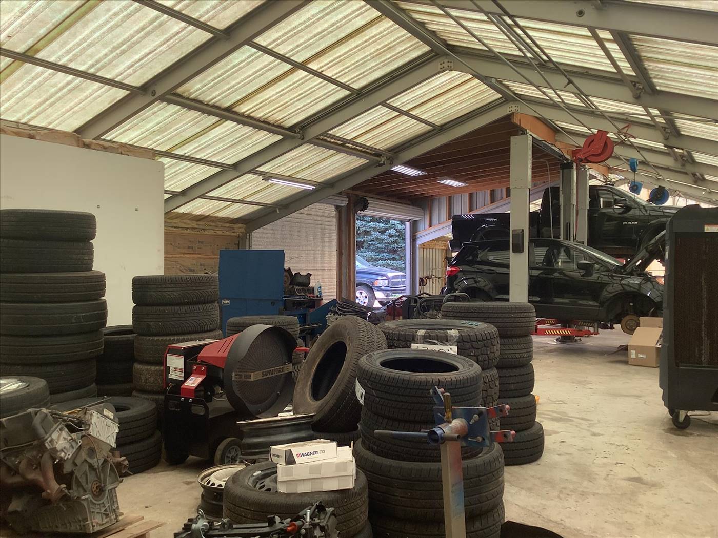 Service bay with lifts and tires at Sahuayo Auto Repair in Mendota